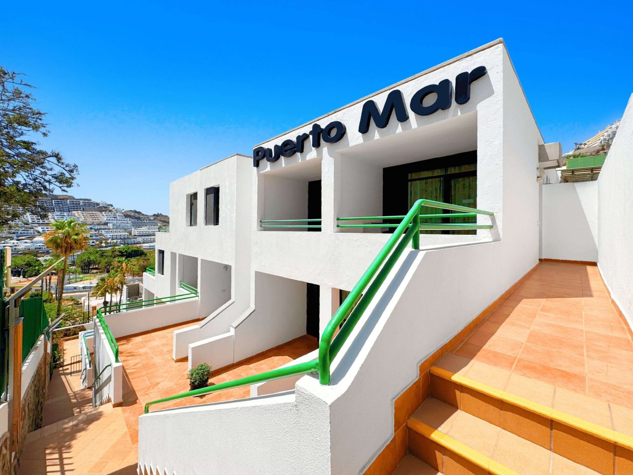 01 Puerto Mar Apartments in Puerto Rico Main Entrance Front View of Holiday Rental Complex in Gran Canaria with Clear Sky scaled c9316382