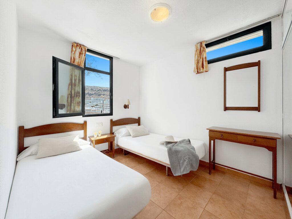 05 Puerto Mar Apartments in Puerto Rico Bright Modern Bedroom with Large Window and White Walls for Coastal Vacation Stay